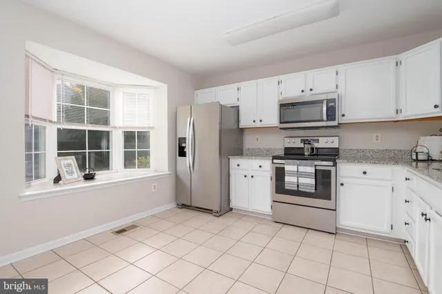 a kitchen with cabinets stainless steel appliances and a window