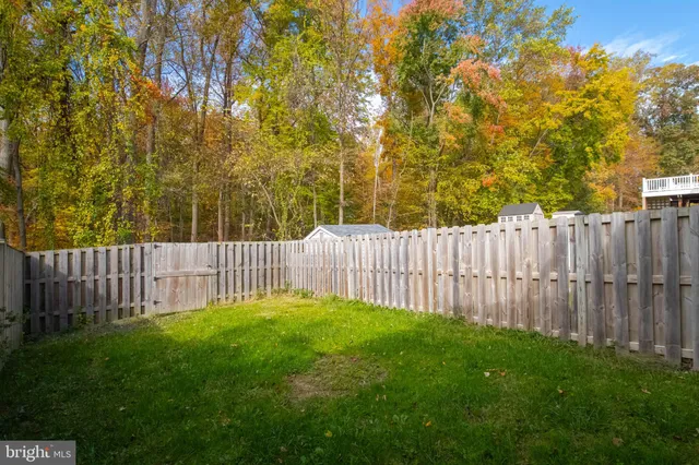 a view of backyard with wooden fence