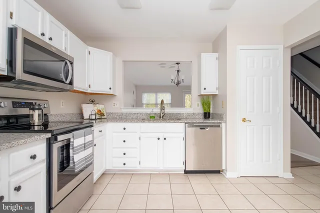a kitchen with stainless steel appliances granite countertop a sink and a stove