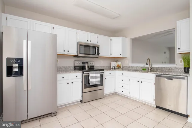 a kitchen with cabinets stainless steel appliances and a counter space