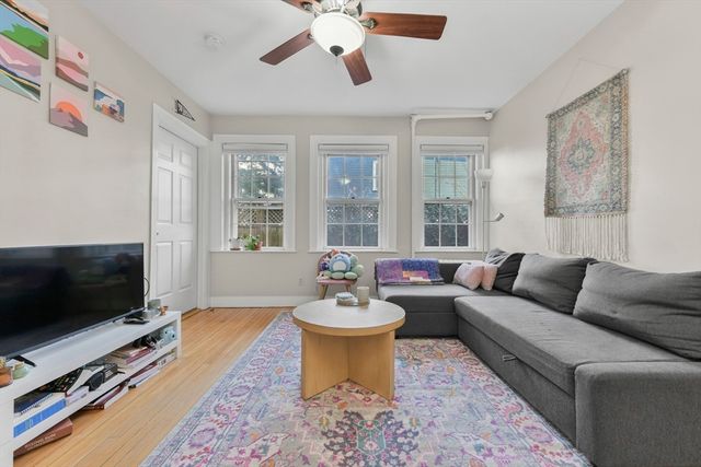 a living room with furniture a flat screen tv and a window