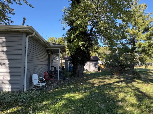 a backyard of a house with table and chairs