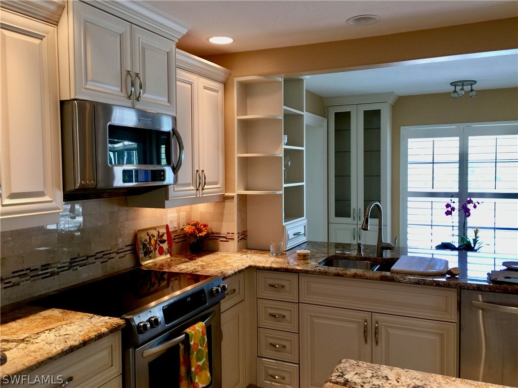 671 Rabbit Road Sanibel, FL 33957 - Photo 16 of 50 a kitchen with granite countertop a stove and a sink