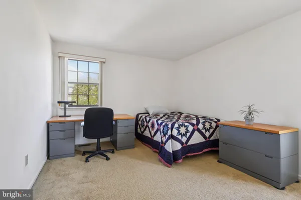 a bedroom with a bed and a workspace