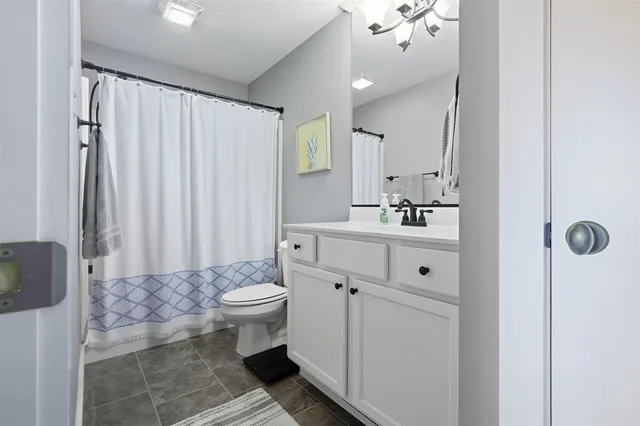a bathroom with a sink a toilet and shower curtain