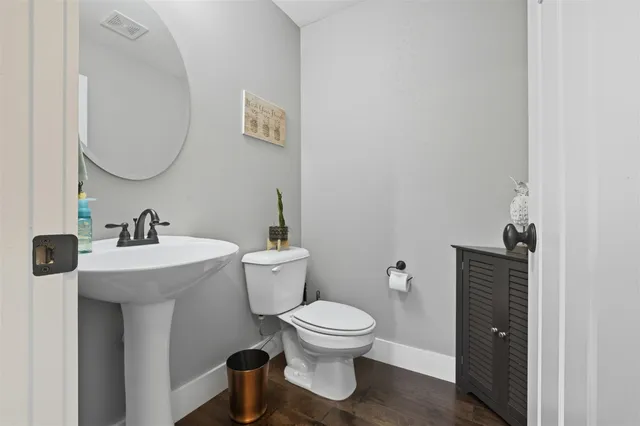 a bathroom with a toilet a sink and mirror