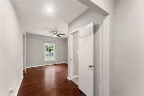 a view of a hallway with wooden floor and a window