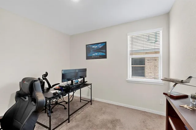 a view of a workspace with furniture and a window