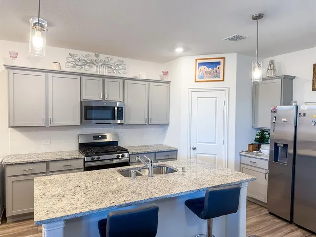 a kitchen with stainless steel appliances granite countertop a sink stove and refrigerator