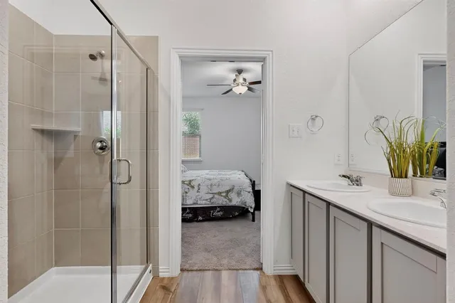 a en suite bathroom with a granite countertop sink and a mirror