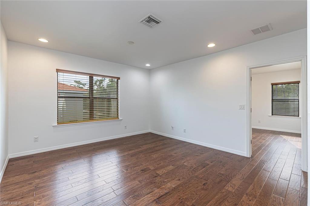 15326 Summit Pl Circle Naples, FL 34119 - Photo 11 of 21 an empty room with wooden floor and windows