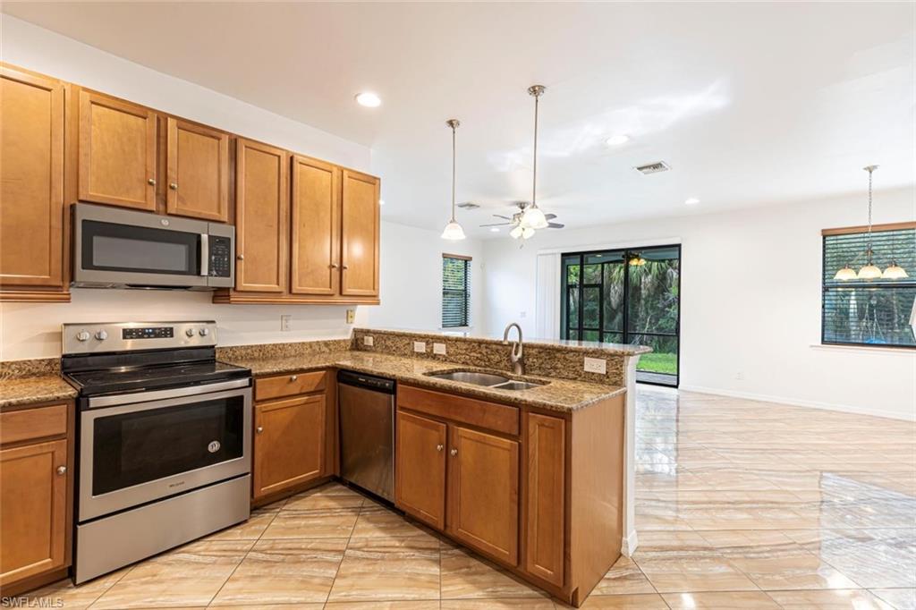 15326 Summit Pl Circle Naples, FL 34119 - Photo 7 of 21 a kitchen with stainless steel appliances granite countertop a stove a sink and a microwave