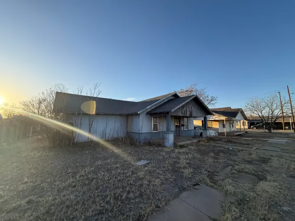 a dirt road with a building in the background