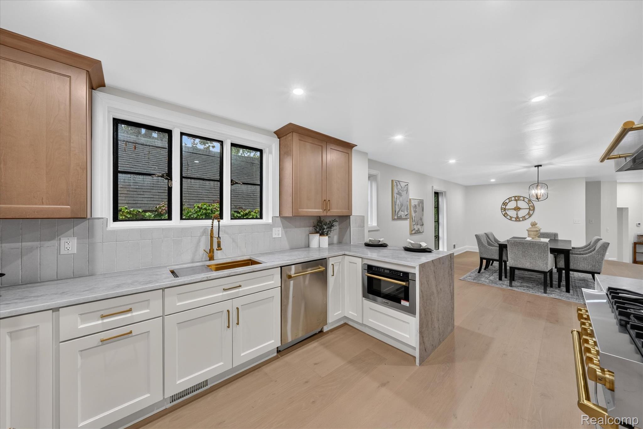 3250 Sherbourne Road Detroit, MI 48221 - Photo 15 of 36 White shaker-style cabinetry with gold-tone hardware, stainless steel dishwasher, integrated microwave, wood-finish flooring, and recessed lighting