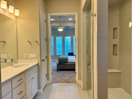 a en suite bathroom with a sink a mirror and a shower