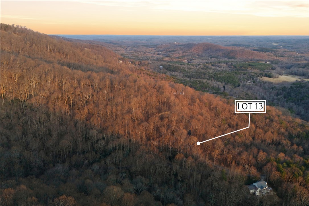 Lot 13 Hideaway Hill Way Landrum, SC 29356 - Photo 10 of 17 An aerial view showcases a lot within a verdant, expansive landscape under a clear sky.