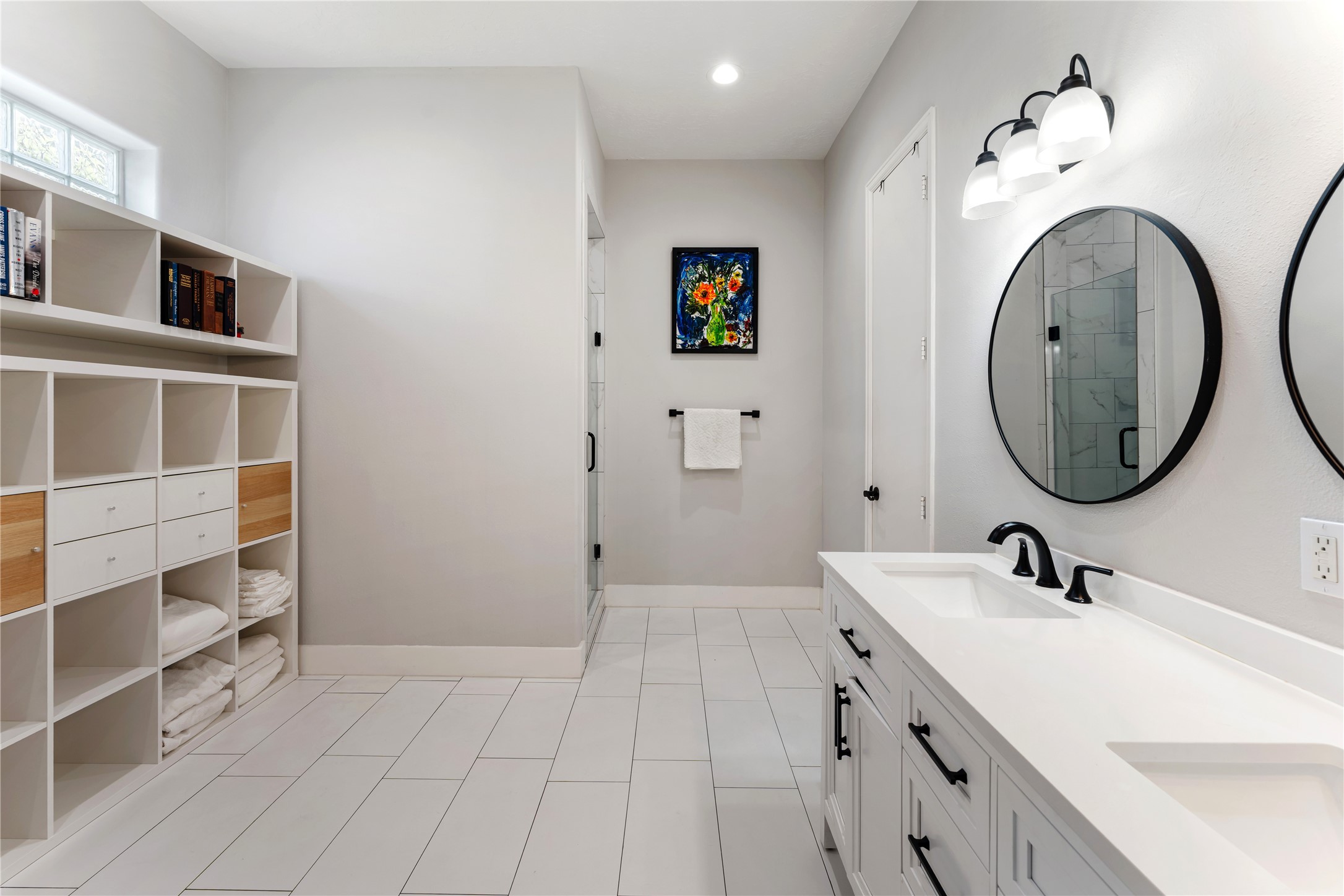 415 West 8th Street Houston, TX 77007 - Photo 10 of 39 Bright, spacious, and beautifully appointed, this luxurious bathroom offers an ideal blend of sophistication and practicality. Custom built-in storage provides exceptional organization while preserving the room's open, airy feel. The seamless connection to the primary suite creates a true spa-inspired owner's retreat.