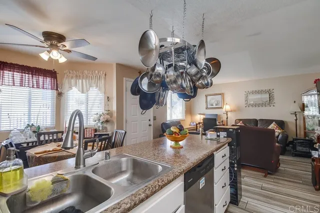 a kitchen with a sink granite counter top a dining table and chairs