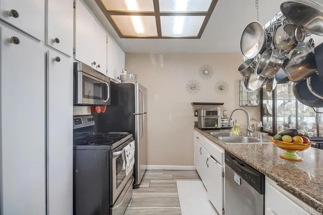 a kitchen with stainless steel appliances granite countertop a sink a stove and a refrigerator