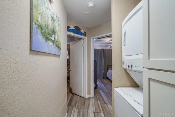 a view of a hallway with entryway and wooden floor