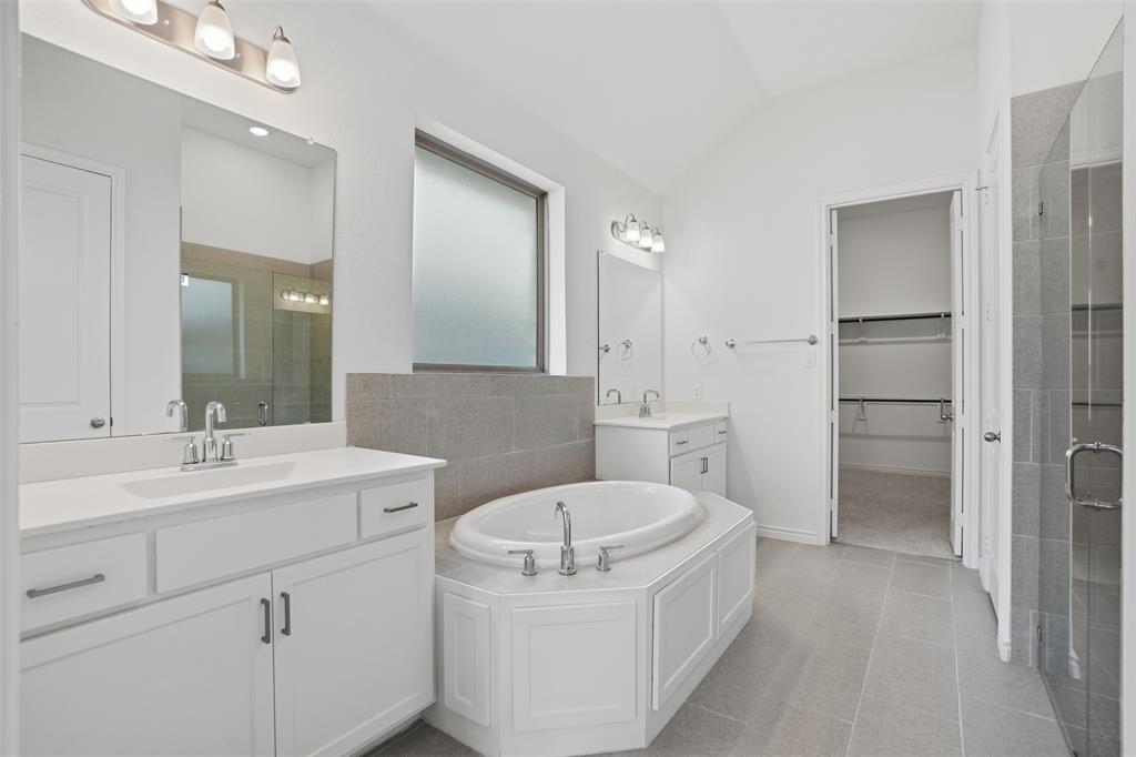 537 Oakmoss Street Little Elm, TX 76227 - Photo 14 of 39 a bathroom with a sink a bathtub a mirror and vanity