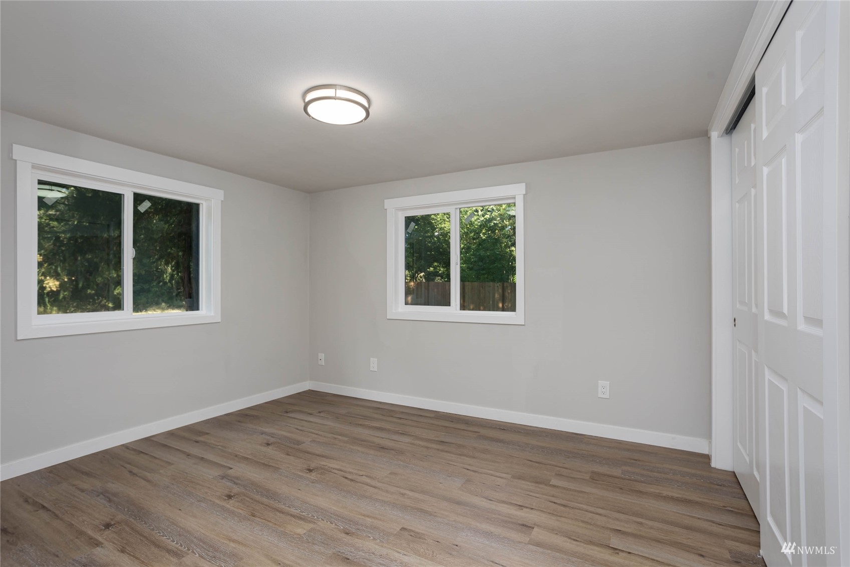 12419 Southeast 95th Way Renton, WA 98056 - Photo 17 of 30 a view of an empty room with wooden floor and a window