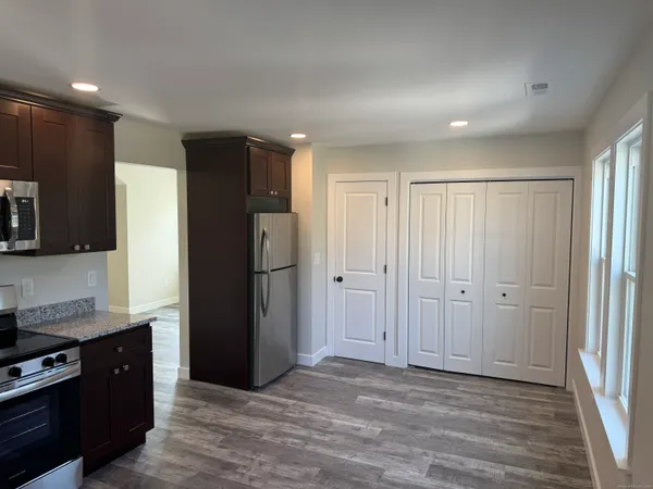 a view of a refrigerator in kitchen and wooden floor