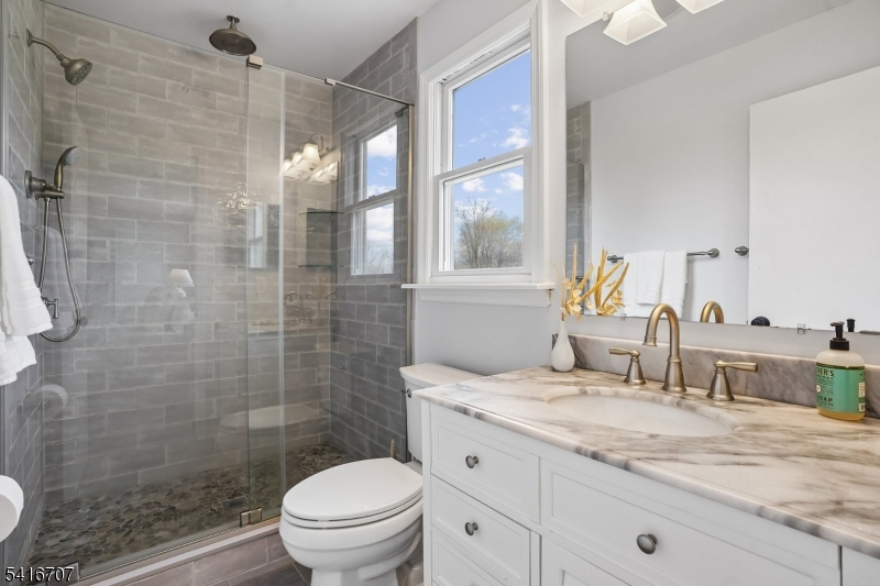 18 Juniper Way Bernards, NJ 07920 - Photo 18 of 31 a bathroom with a granite countertop sink a toilet a mirror and shower