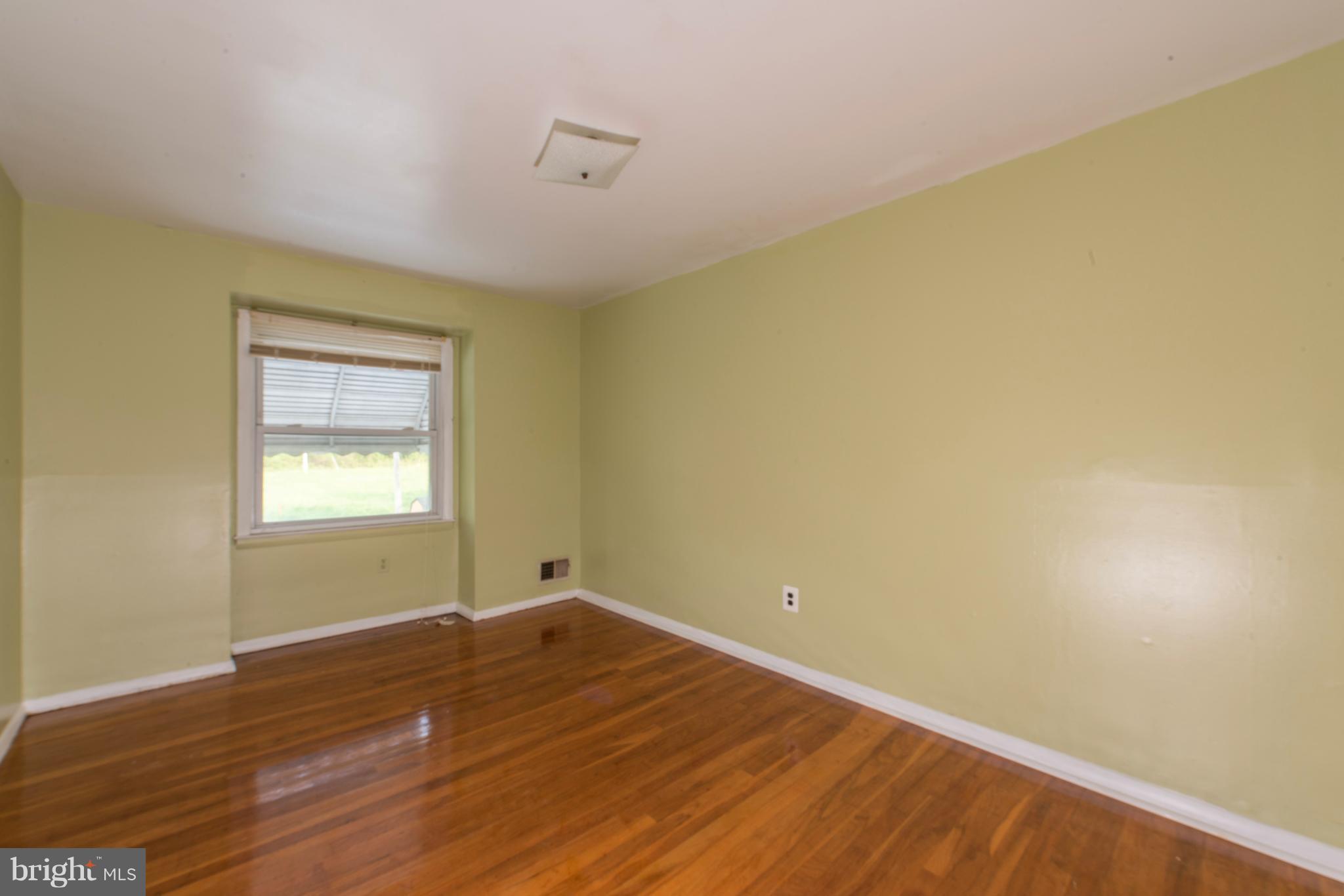 5607 Whitby Road Baltimore, MD 21206 - Photo 11 of 20 a view of an empty room with wooden floor and a window