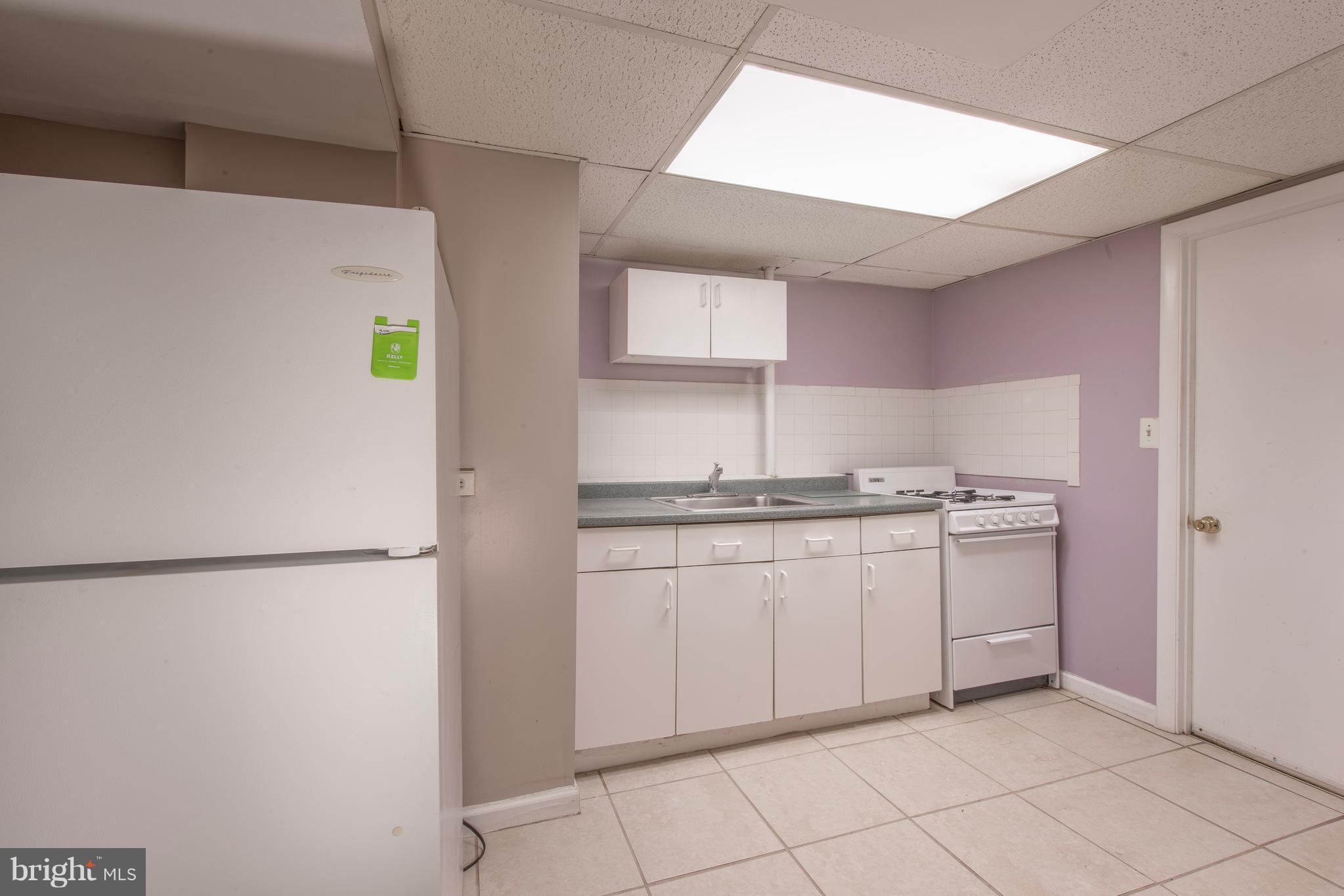5607 Whitby Road Baltimore, MD 21206 - Photo 17 of 20 a kitchen with a refrigerator and white cabinets
