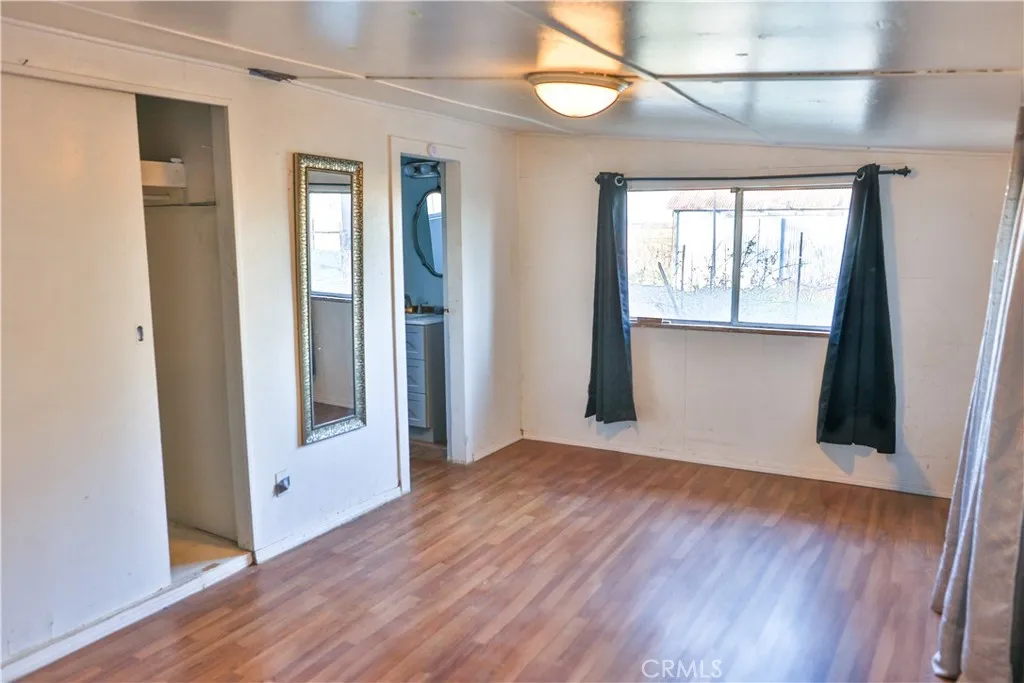 10825 Paskenta Road Red Bluff, CA 96080 - Photo 16 of 42 a view of an empty room with wooden floor and a window