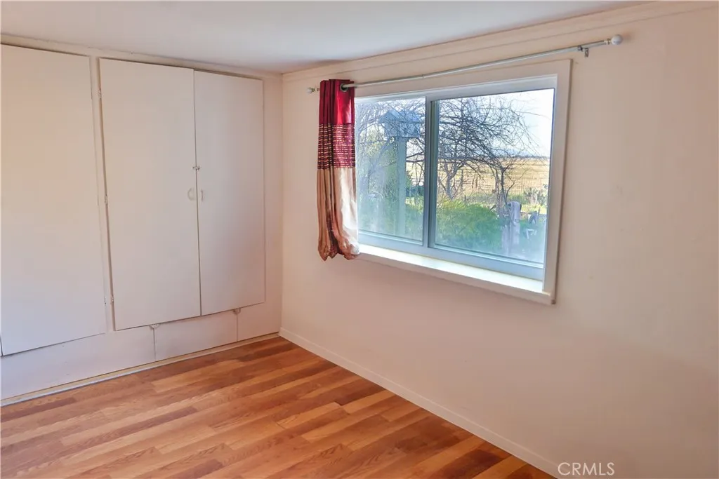 10825 Paskenta Road Red Bluff, CA 96080 - Photo 19 of 42 a view of empty room with wooden floor and fan