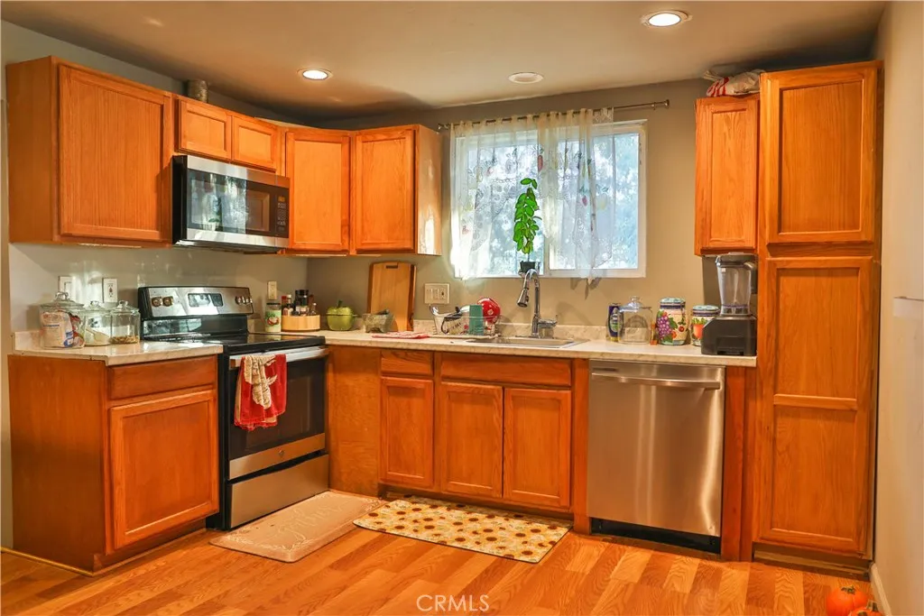 10825 Paskenta Road Red Bluff, CA 96080 - Photo 24 of 42 a kitchen with stainless steel appliances granite countertop wooden cabinets a sink and a large window