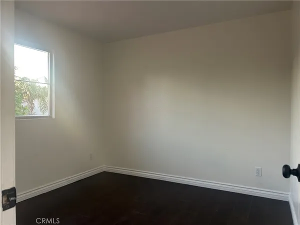 a view of an empty room with closet and a window