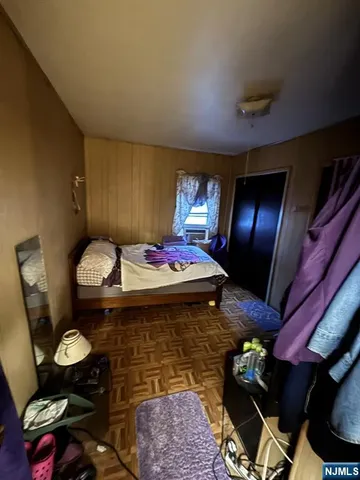 a bedroom with a bed and wooden floor