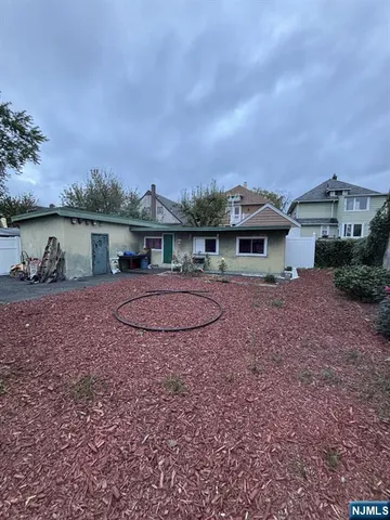 a view of a house with backyard and sitting area