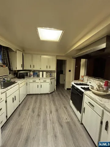 a kitchen with wooden floors and white appliances