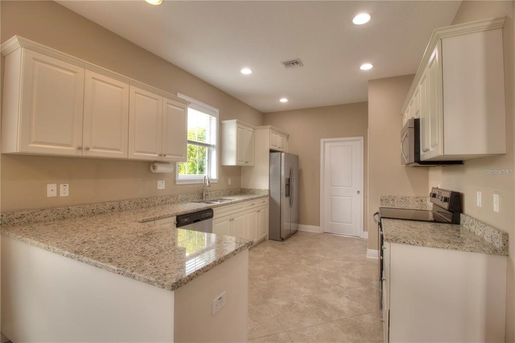 1922 Southeast 29th Street Ocala, FL 34471 - Photo 8 of 29 a kitchen with stainless steel appliances granite countertop a sink stove and refrigerator