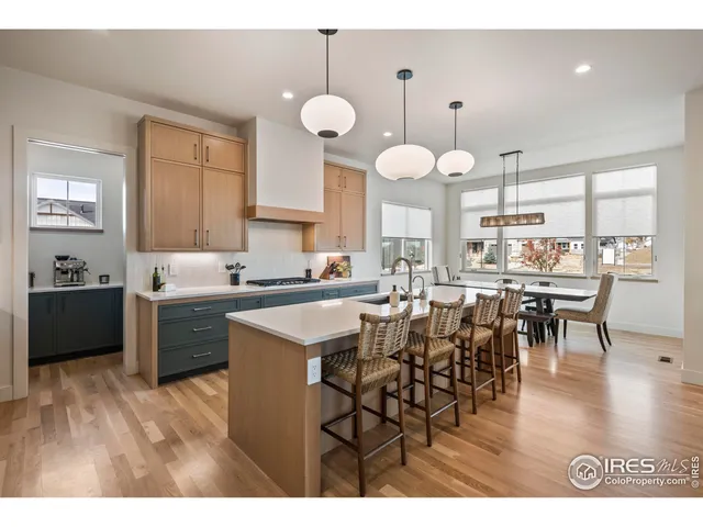 a kitchen with a dining table chairs and white cabinets