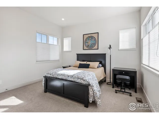 a bedroom with a bed a table and painting