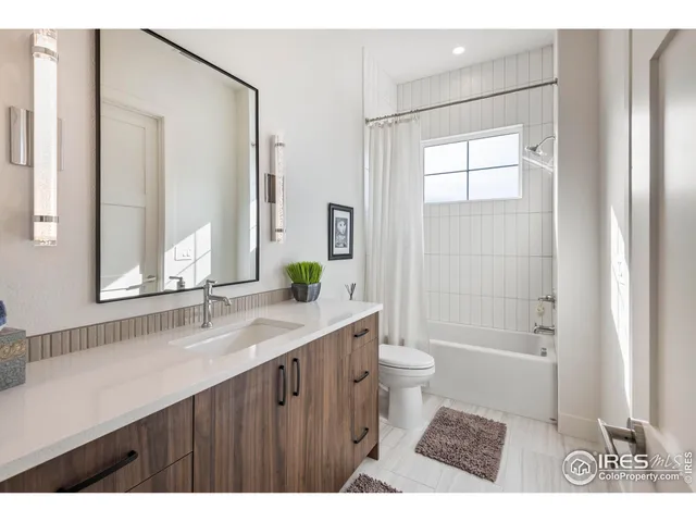 a bathroom with a granite countertop sink toilet a shower a mirror and a bathtub