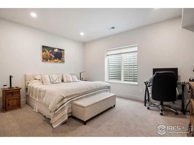 a spacious bedroom with a bed a desk and chair