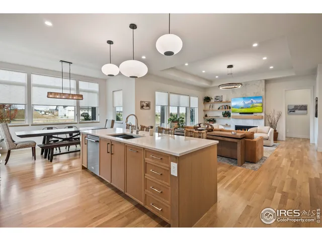 a kitchen with stainless steel appliances kitchen island granite countertop a sink cabinets and wooden floor