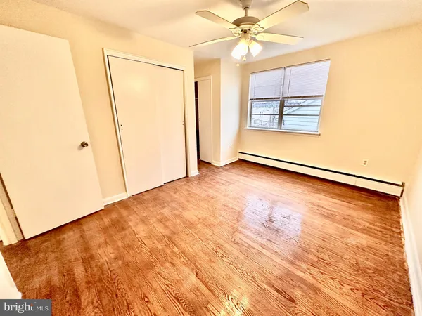 an empty room with windows and fan