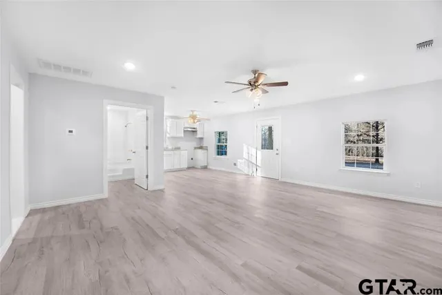 a view of empty room with wooden floor