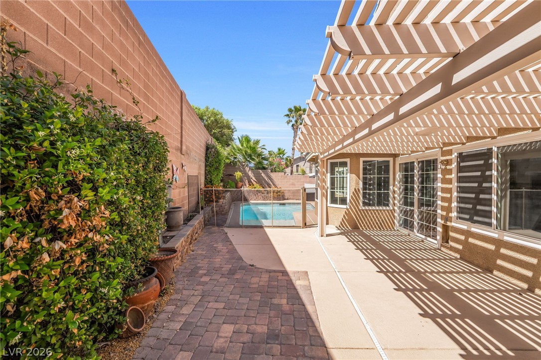 271 Pointe Ranier Avenue Henderson, NV 89012 - Photo 24 of 26 This serene backyard features a refreshing pool, a spacious patio, and a charming pergola.
