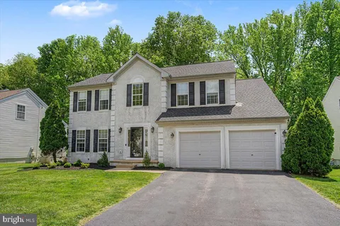 a front view of a house with a garden and yard