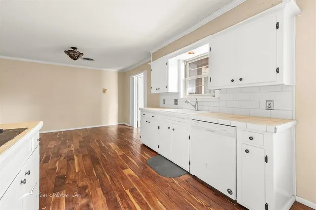 a kitchen with stainless steel appliances cabinets and wooden floor