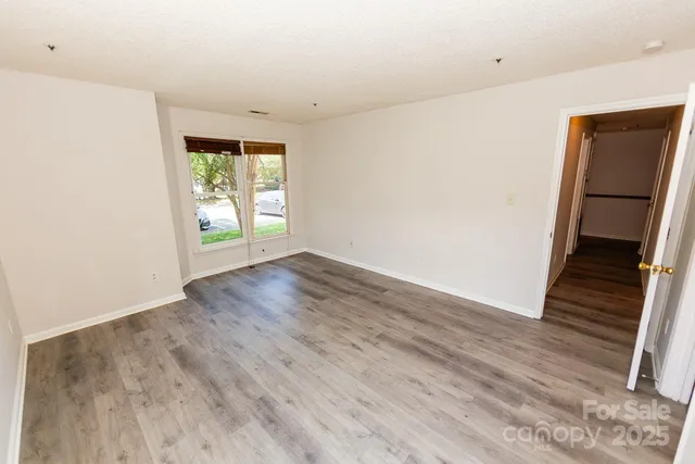 an empty room with wooden floor and a window