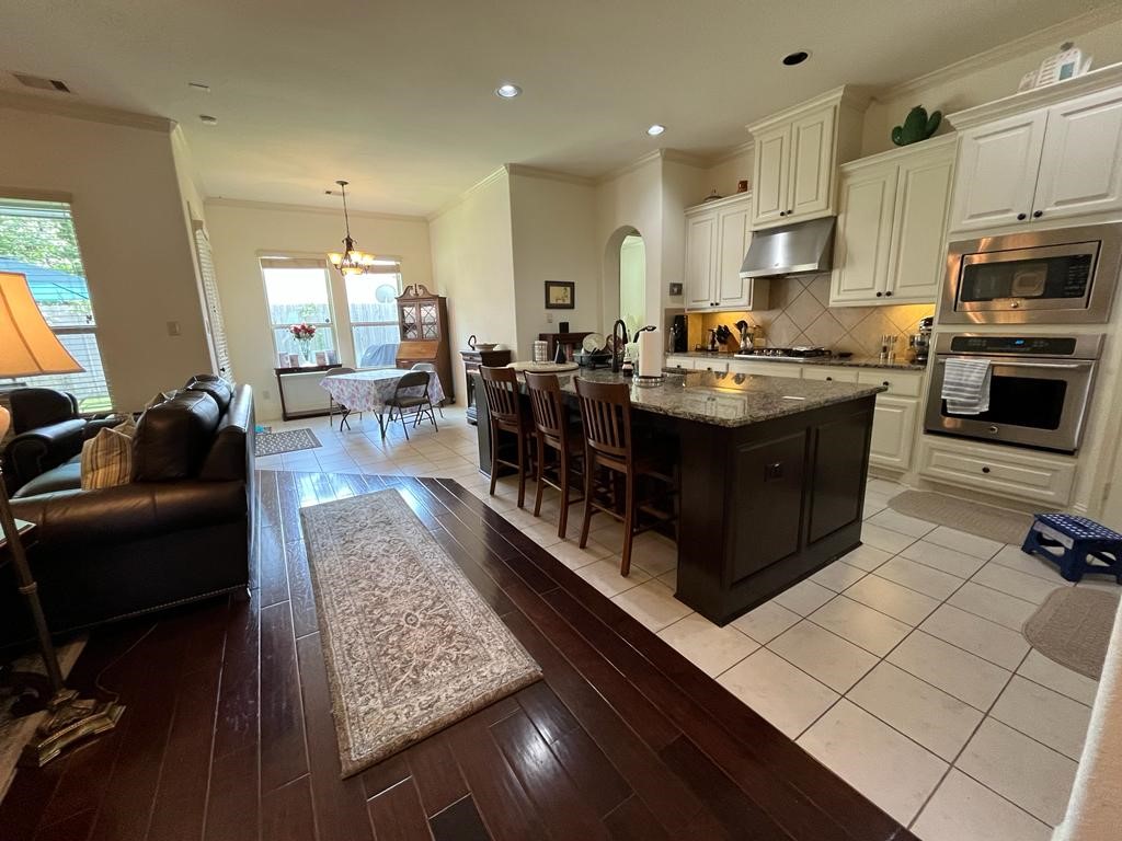 13117 Stoneleigh Terrace Drive Houston, TX 77077 - Photo 23 of 23 a large kitchen with stainless steel appliances granite countertop a large counter top a stove a chimney a sink and a refrigerator
